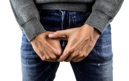 man in jeans covering private area