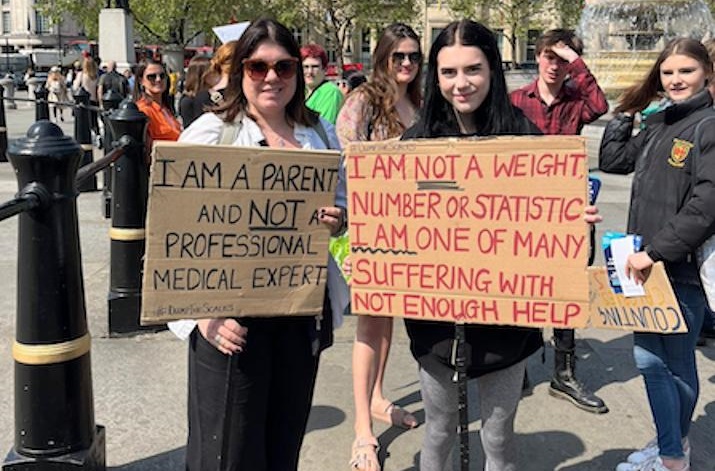 Two women holding up signs around eating disorders