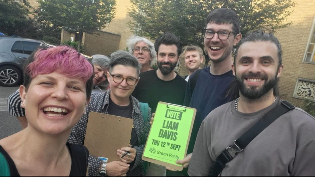 A group of activist holding a clipboard saying 'Vote Liam Davis' 