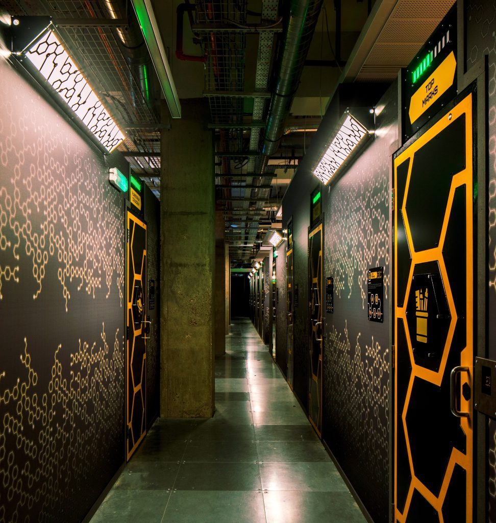 The futuristic looking corridor in Escape Arcade's laboratory with doors for each room