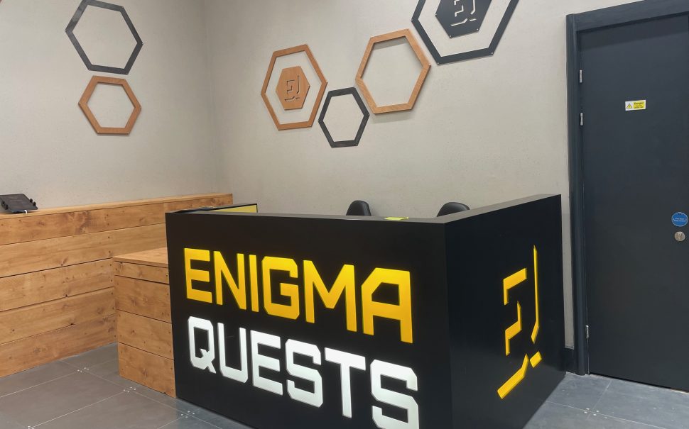 The reception at Escape Arcade with its Enigma Quests branding on the front of the desk