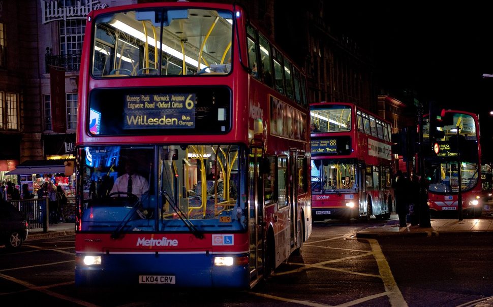 London buses driving through the city at night