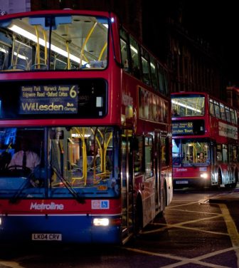 London buses driving through the city at night