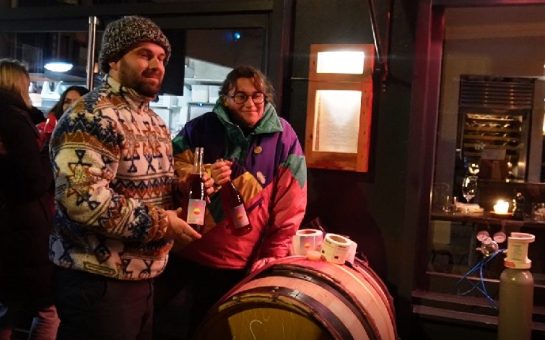 Wine makers holding bottles of Boujolais Nouveau