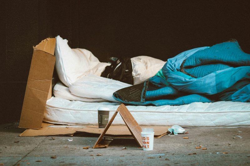 A mattress with a duvet on the street